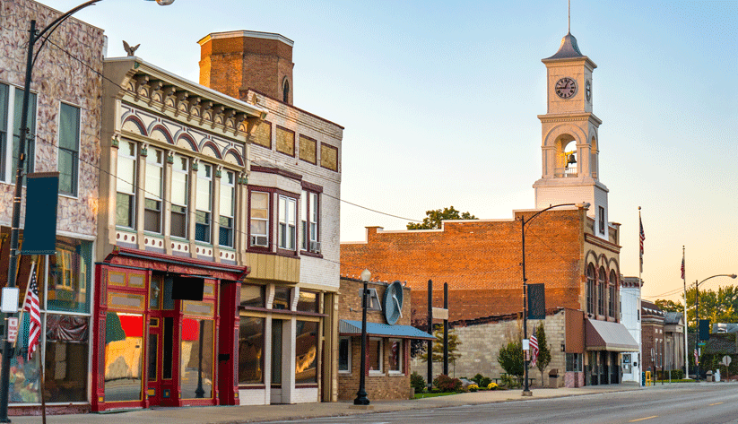 photograph of storefront buildings along a small town street at sunset