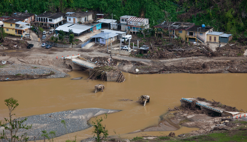 Roads, houses, and the bridge carried away by flood waters of the Rio Charco Abajo. Refuse from upstream forests are deposited high above the river banks. As much as 40 inches of rain fell from Hurricane Maria, a category 4 storm that hit Puerto Rico with winds up to 155 mph. Photo by Andrea Booher, courtesy of the Federal Emergency Management Agency