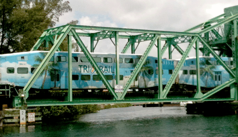 photograph of a TriRail train crossing over a tressle bridge