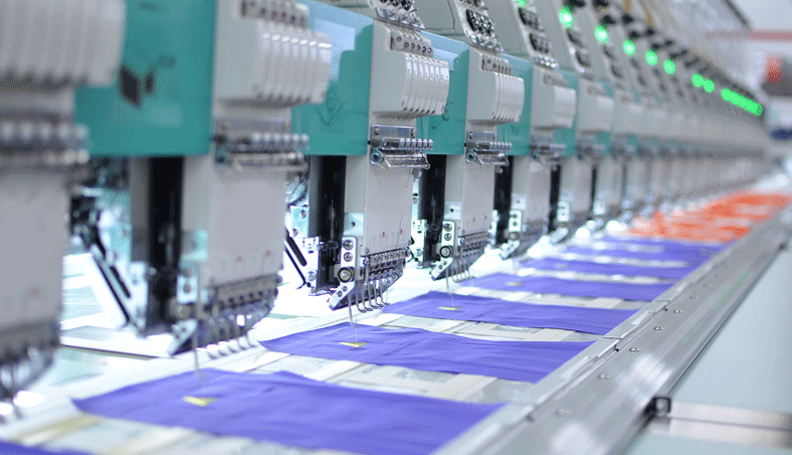 a row of automated sewing machines in a factory