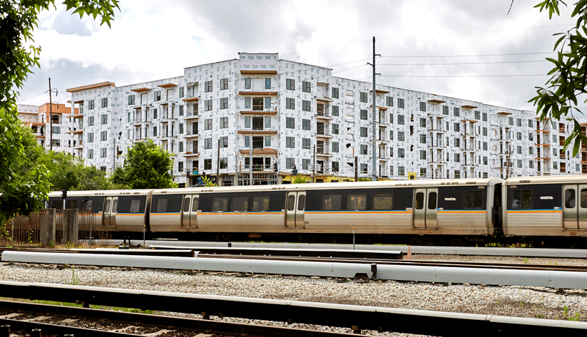 photograph of a MARTA train passing in front of a new housing development under construction