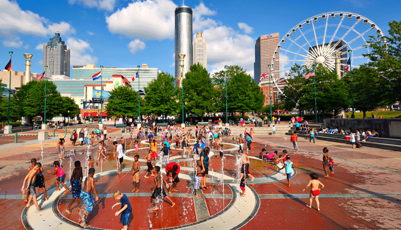 people playing in the fountains of Atlanta's Centennial Olympic Park on a bright summer day