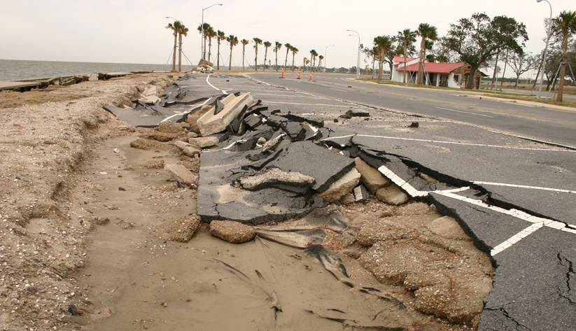 photograph of a seaside road buckled and collapsed from a severe storm